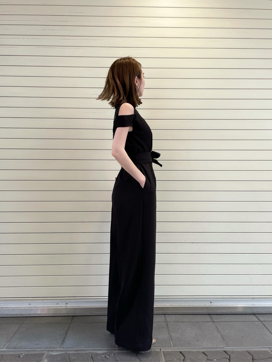 ブラック系のパンツドレス、ゴールド系のネックレスを着用したレディースの春コーディネートの3枚目の写真