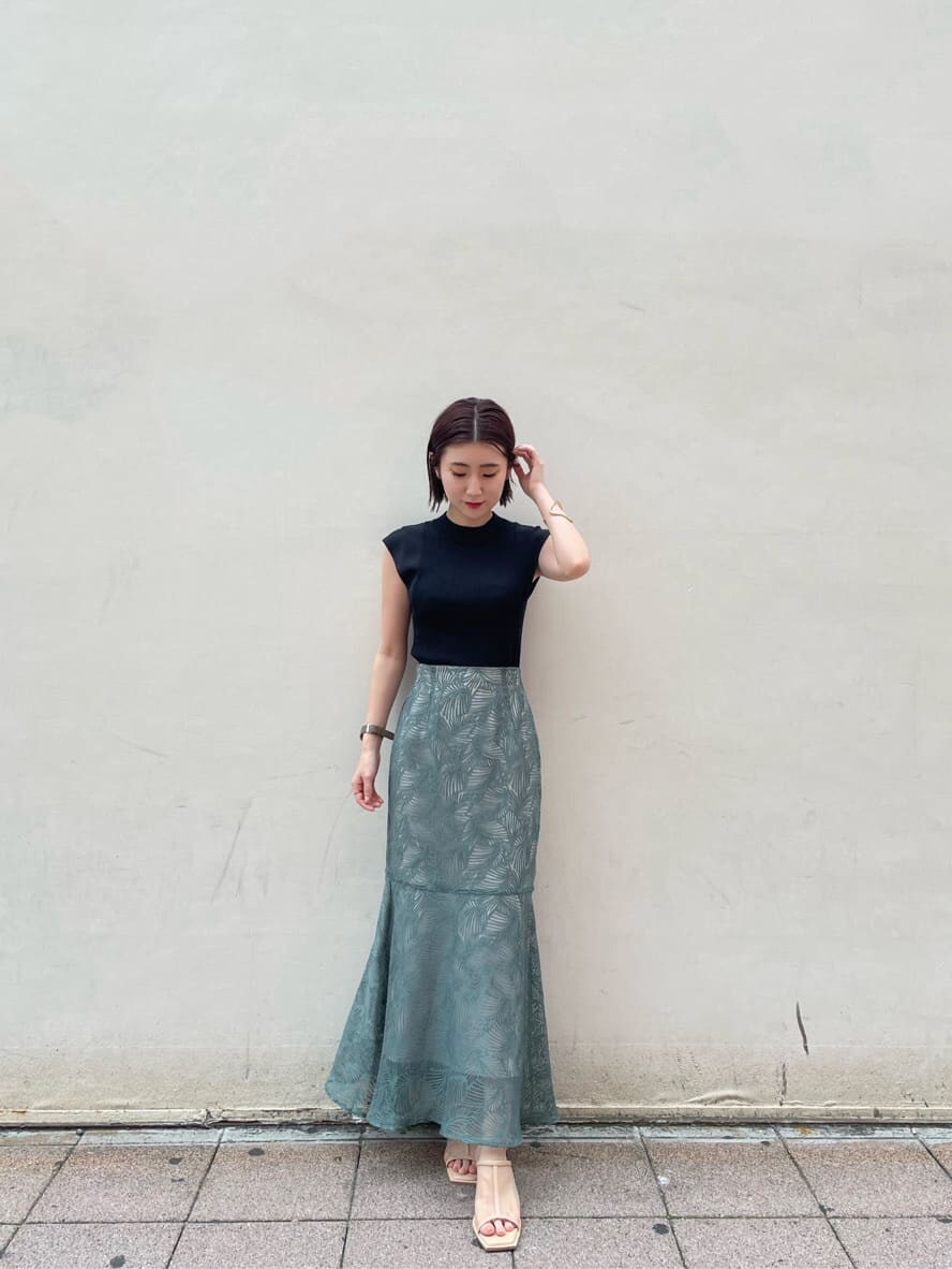 ブルー系のスカート、ベージュ系のサンダル、ブラック系のニット/セーターを着用したレディースの夏コーディネートの5枚目の写真