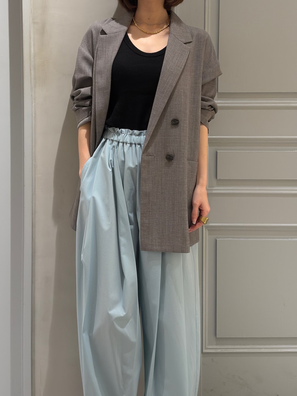 グレー系のテーラードジャケット、グリーン系のその他パンツ、シルバー系のパンプスを着用したレディースの冬コーディネートの5枚目の写真