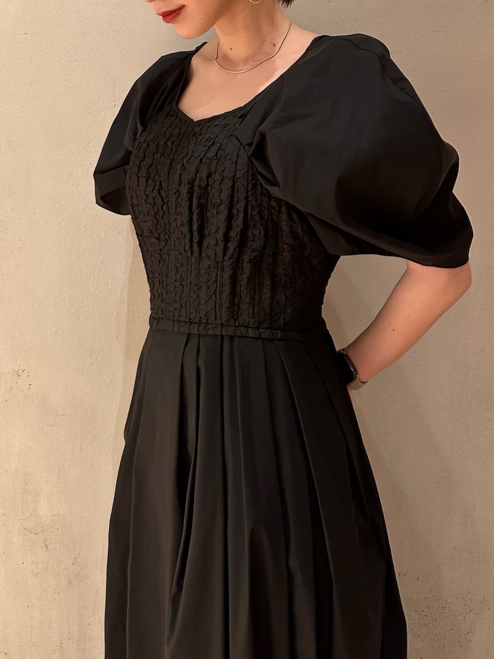 ブラック系のワンピース、ホワイト系のスニーカー、ゴールド系のピアス（両耳用）を着用したレディースの夏コーディネートの6枚目の写真