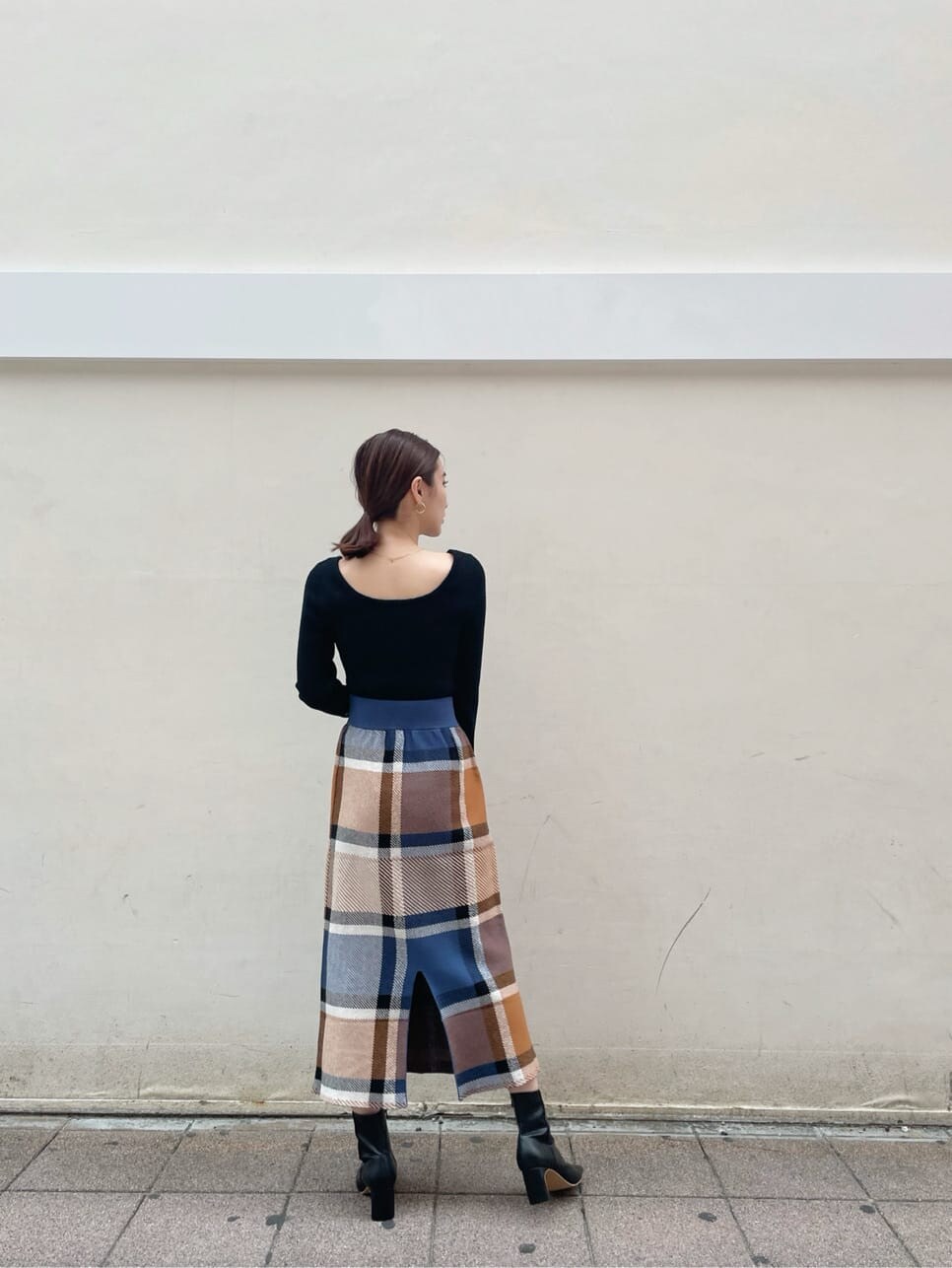 ブラック系のその他シューズ、ブルー系のスカート、ブラック系のニット/セーターを着用したレディースの秋コーディネートの4枚目の写真