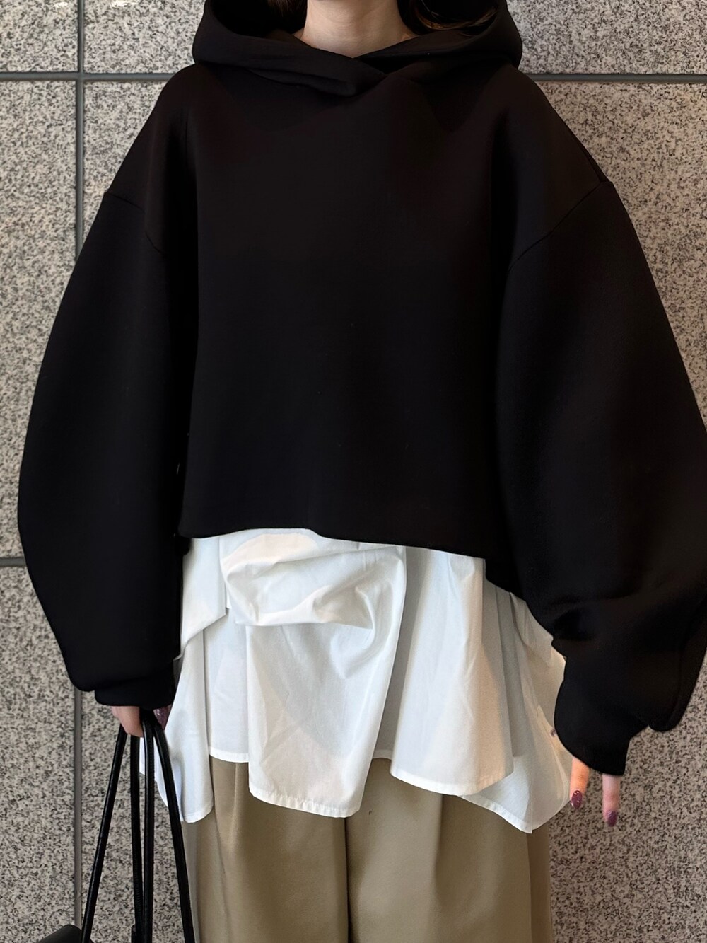 ベージュ系のその他パンツ、ブラック系のボストンバッグ、ブラック系のパーカーを着用したレディースの秋コーディネートの6枚目の写真