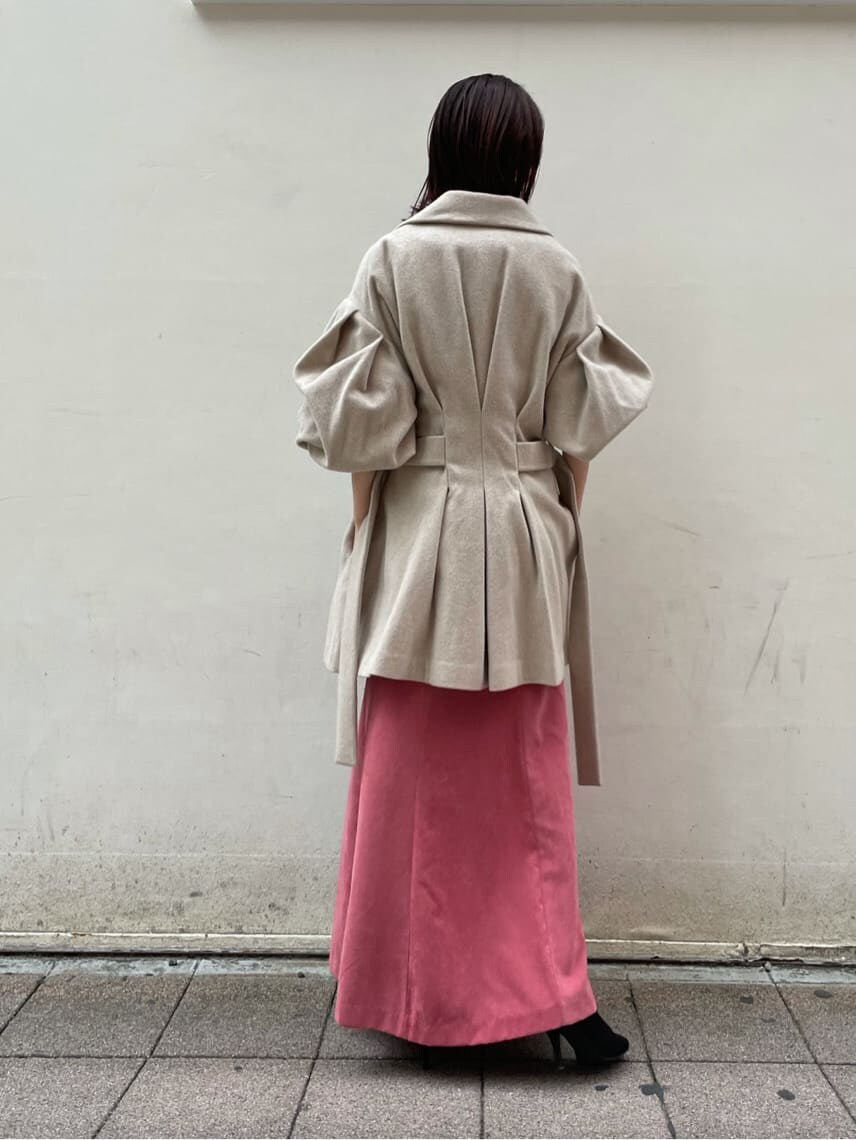 ブラック系のブーツ、ベージュ系のその他アウター、ピンク系のスカートを着用したレディースの秋コーディネートの8枚目の写真