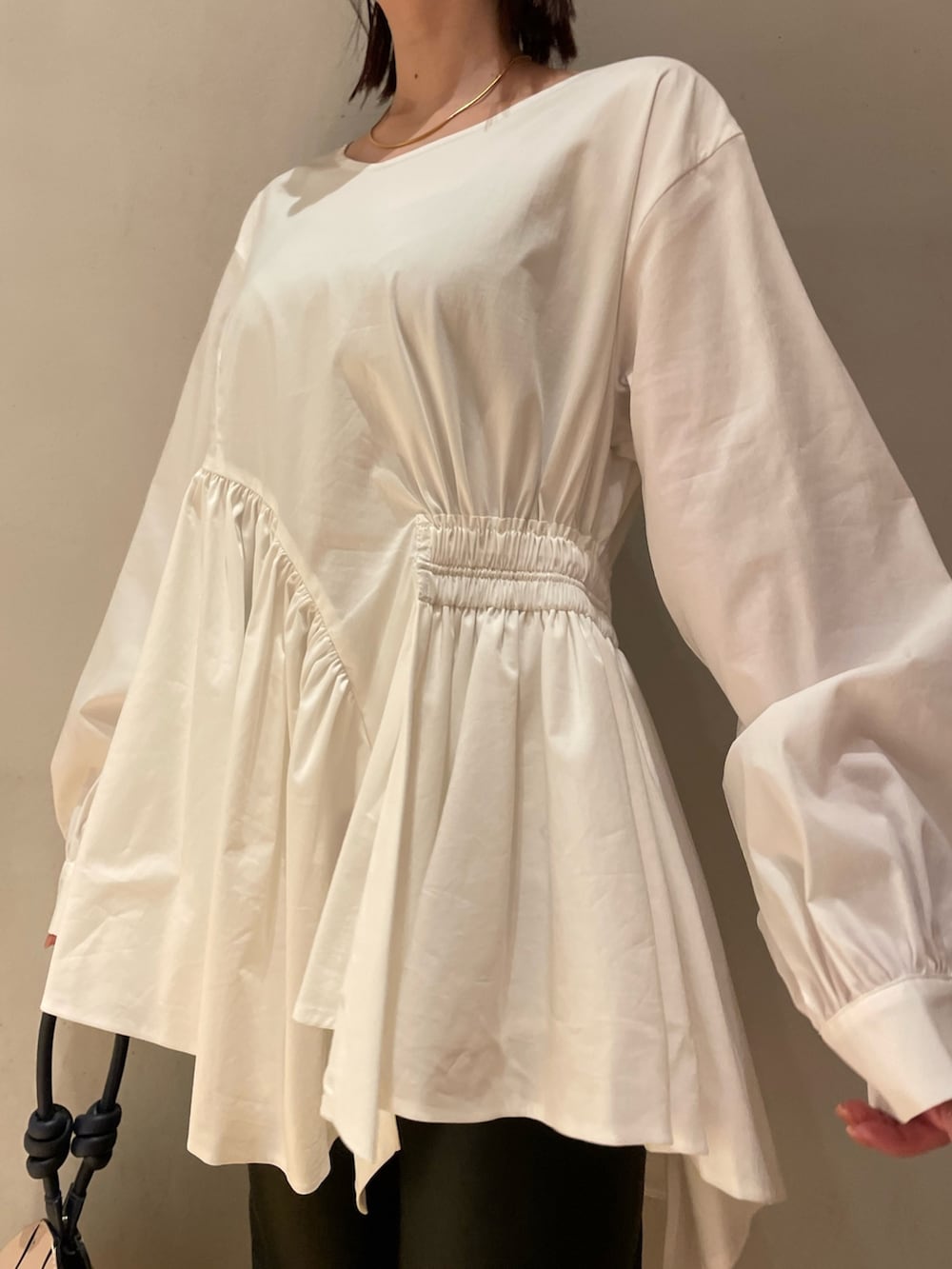 ホワイト系のシャツ/ブラウス、ブラック系のその他パンツ、ベージュ系のハンドバッグを着用したレディースの秋コーディネートの2枚目の写真