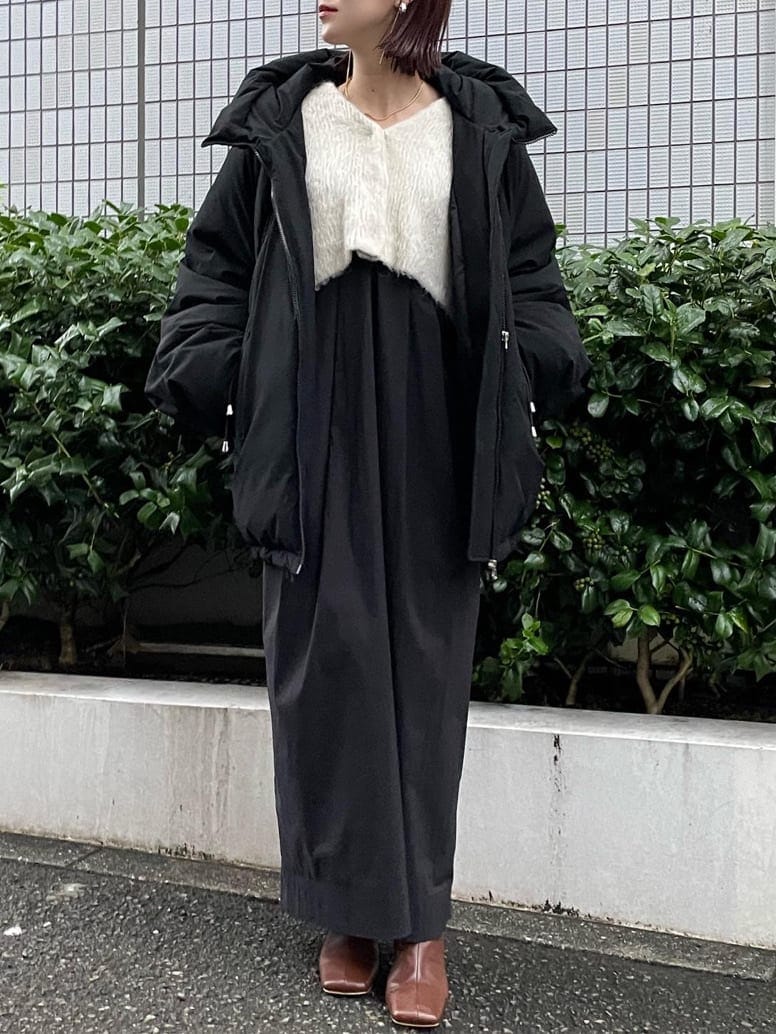 ブラック系のダウンジャケット/コート、ブラウン系のブーツ、ホワイト系のワンピースを着用したレディースの秋コーディネートの6枚目の写真