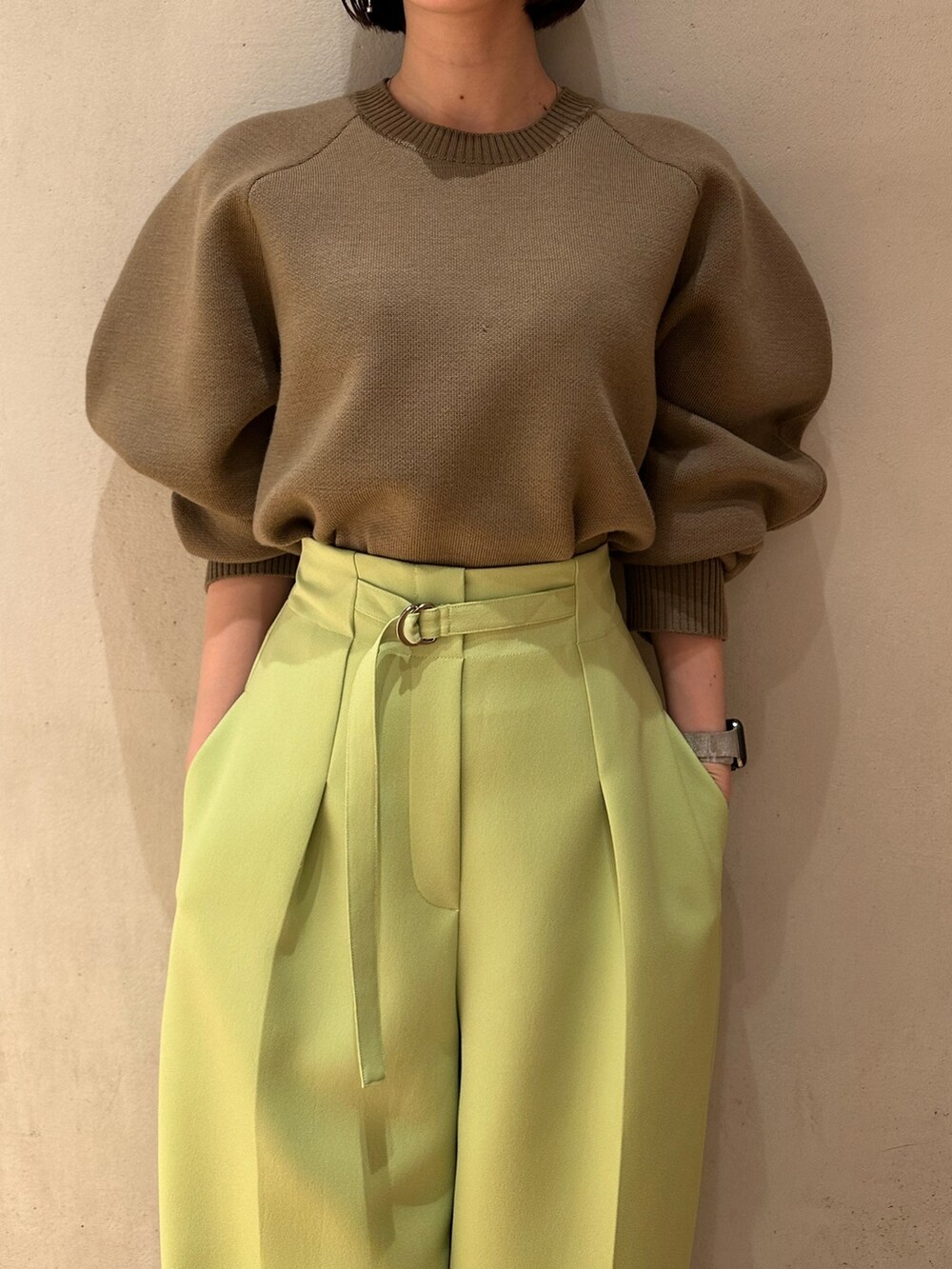 グリーン系のその他パンツ、ベージュ系のニット/セーター、ブラック系のブーティを着用したレディースの冬コーディネートの6枚目の写真