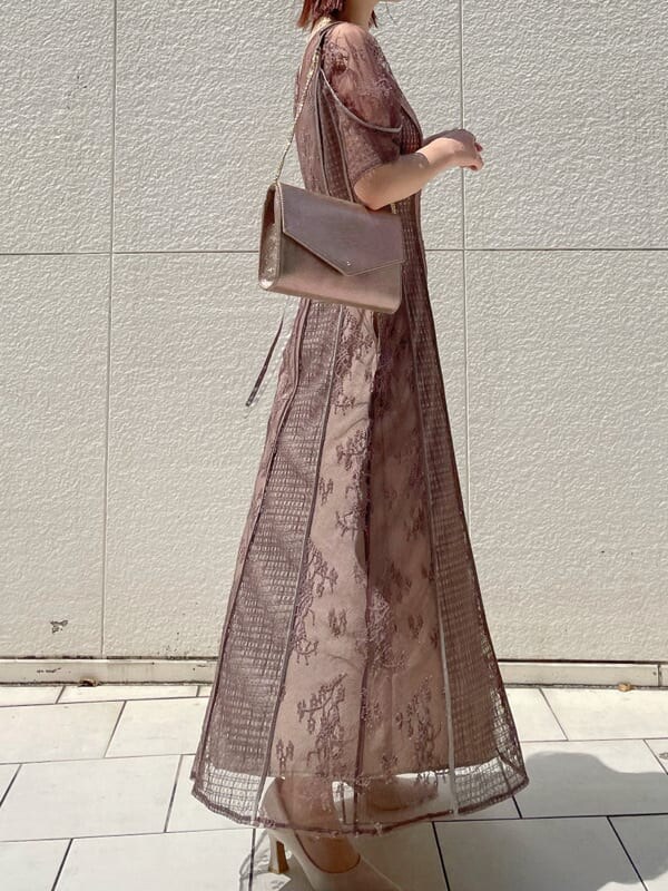 ベージュ系のパンプス、ゴールド系のクラッチバッグ、ベージュ系のドレスを着用したレディースの夏コーディネートの2枚目の写真
