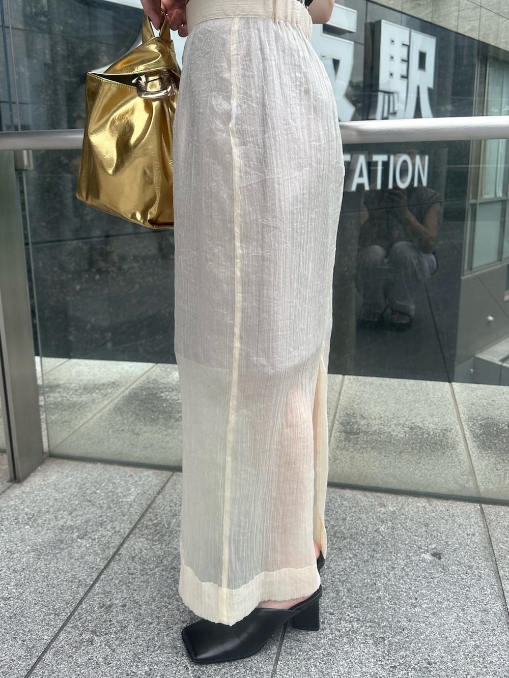 ブラック系のパンプス、ベージュ系のスカート、ブラック系のタンクトップを着用したレディースの夏コーディネートの7枚目の写真