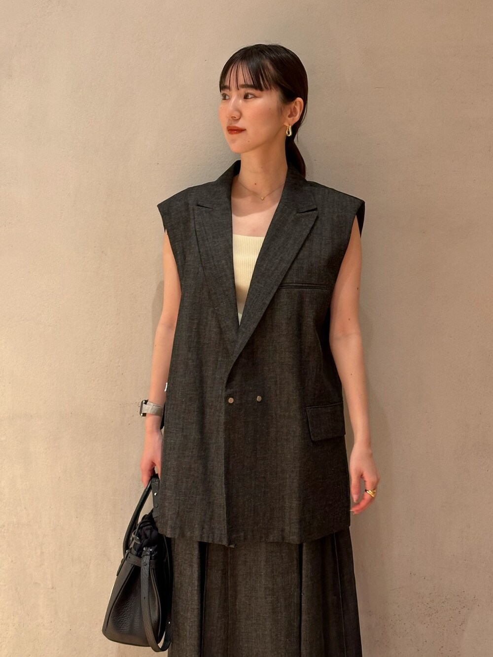 ゴールド系のパンプス、イエロー系のタンクトップ、その他のテーラードジャケットを着用したレディースの春コーディネートの4枚目の写真