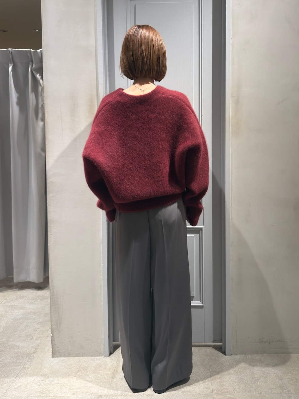 レッド系のカーディガン/ボレロ、グレー系のその他パンツ、ブラック系のローファーを着用したレディースの冬コーディネートの3枚目の写真