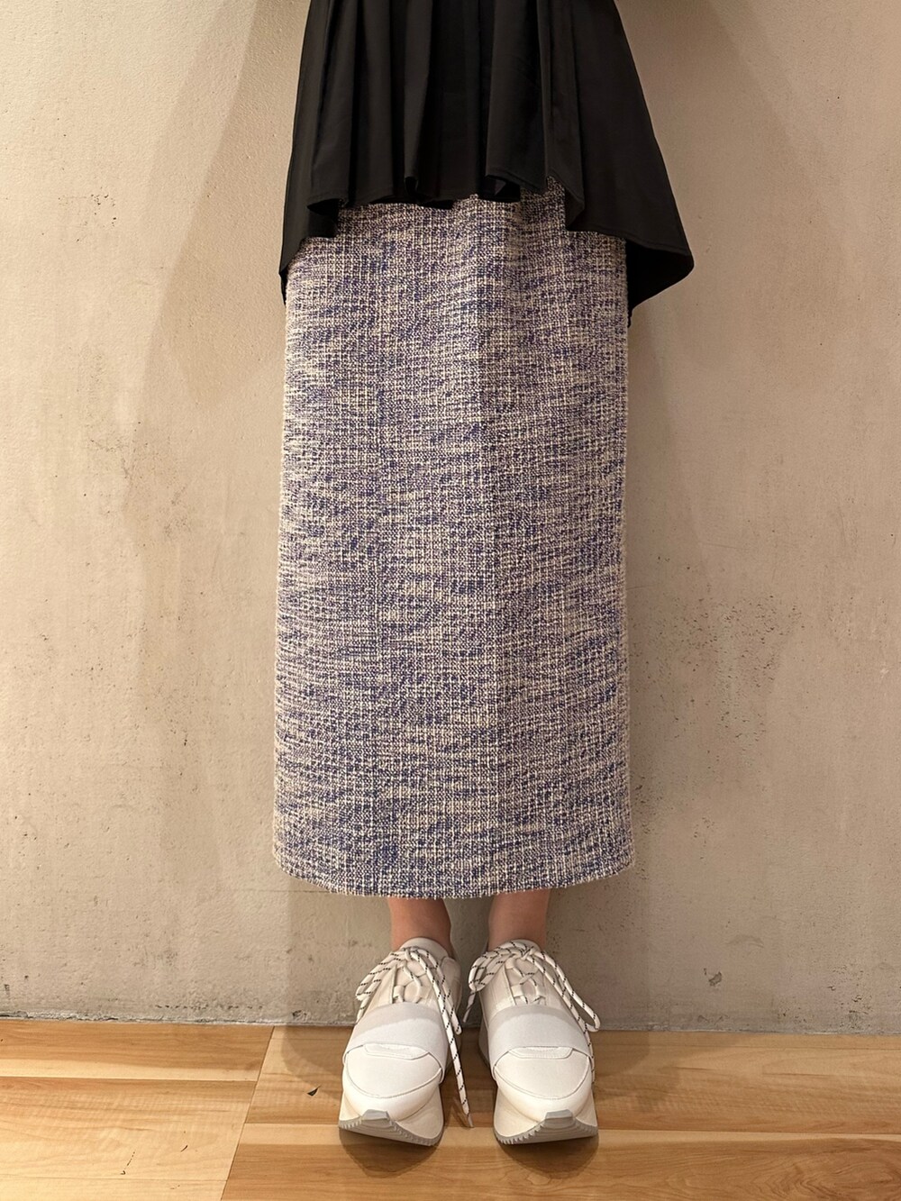 ブラック系のシャツ/ブラウス、ホワイト系のスニーカー、ブルー系のスカートを着用したレディースの春コーディネートの5枚目の写真