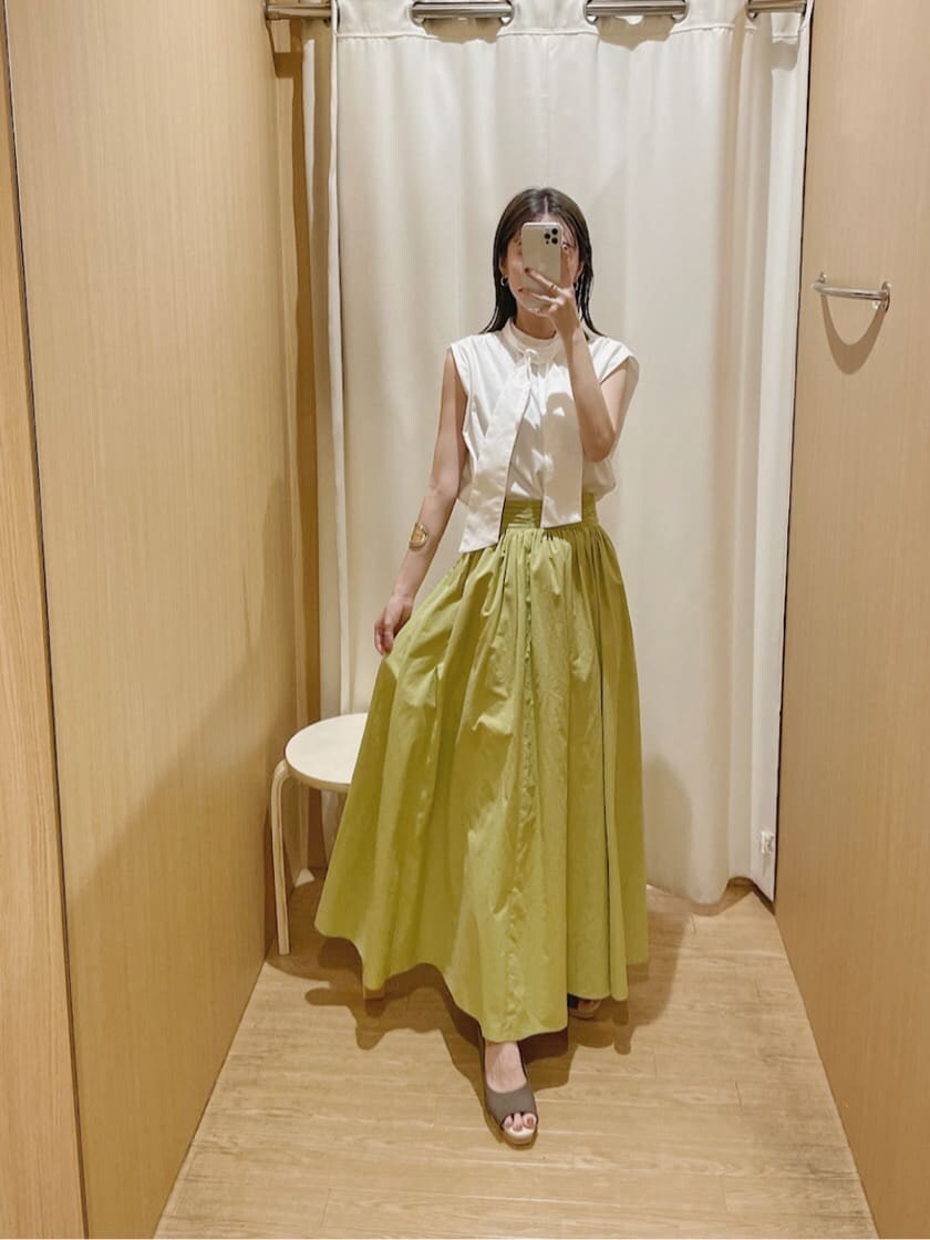 ブラウン系のパンプス、ホワイト系のシャツ/ブラウス、グリーン系のスカートを着用したレディースの夏コーディネートの6枚目の写真