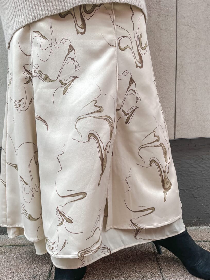 ホワイト系のスカート、ホワイト系のニット/セーター、ホワイト系のTシャツ/カットソーを着用したレディースの秋コーディネートの6枚目の写真