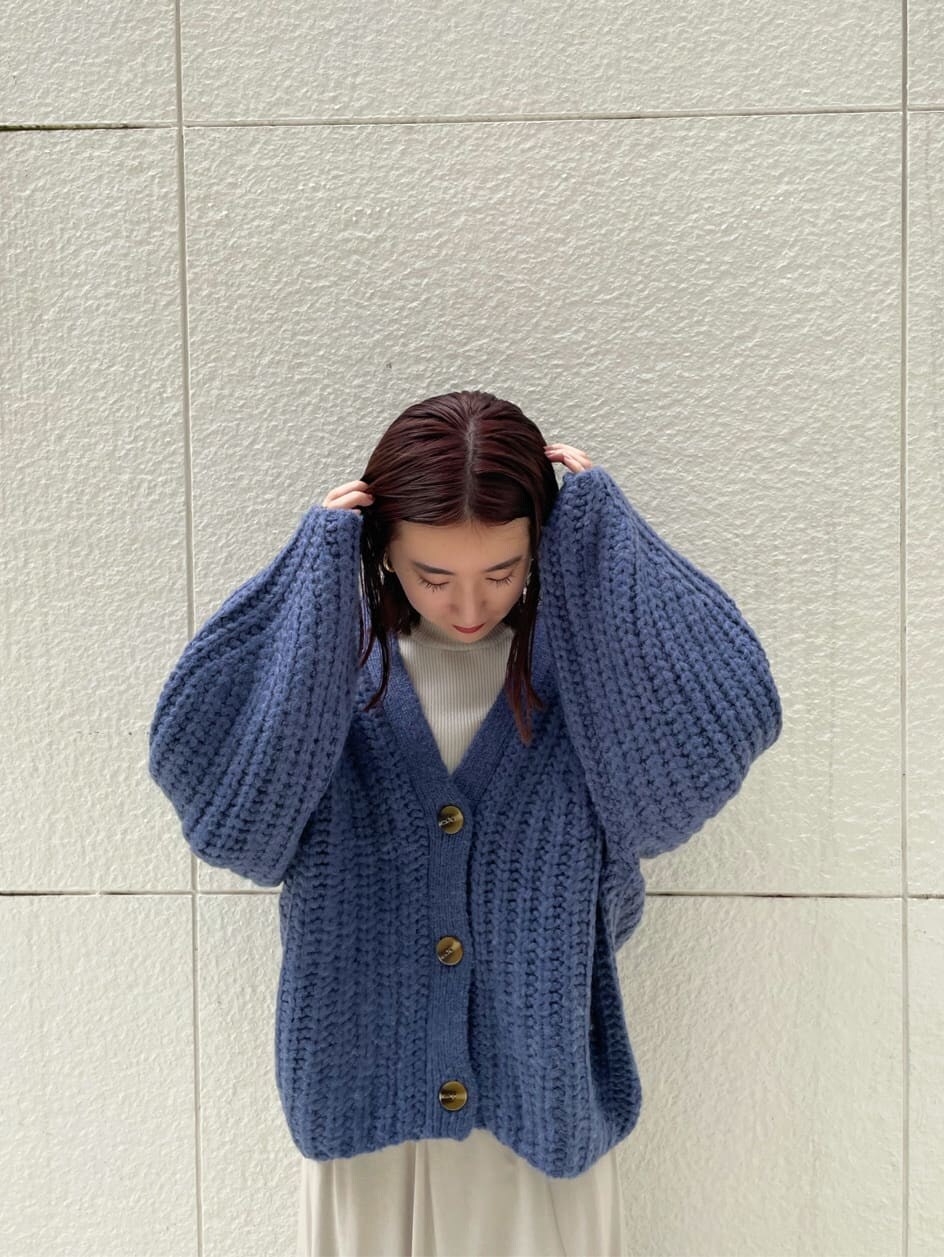 グレー系のニット/セーター、グレー系のスカート、ブラック系のその他シューズを着用したレディースの秋コーディネートの4枚目の写真