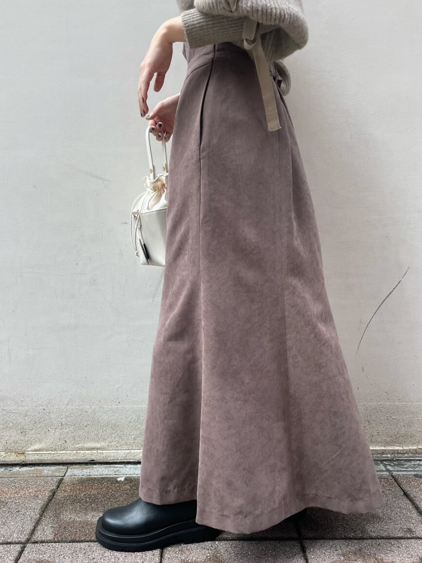 ブラック系のブーツ、ブラウン系のスカート、ベージュ系のニット/セーターを着用したレディースの秋コーディネートの5枚目の写真