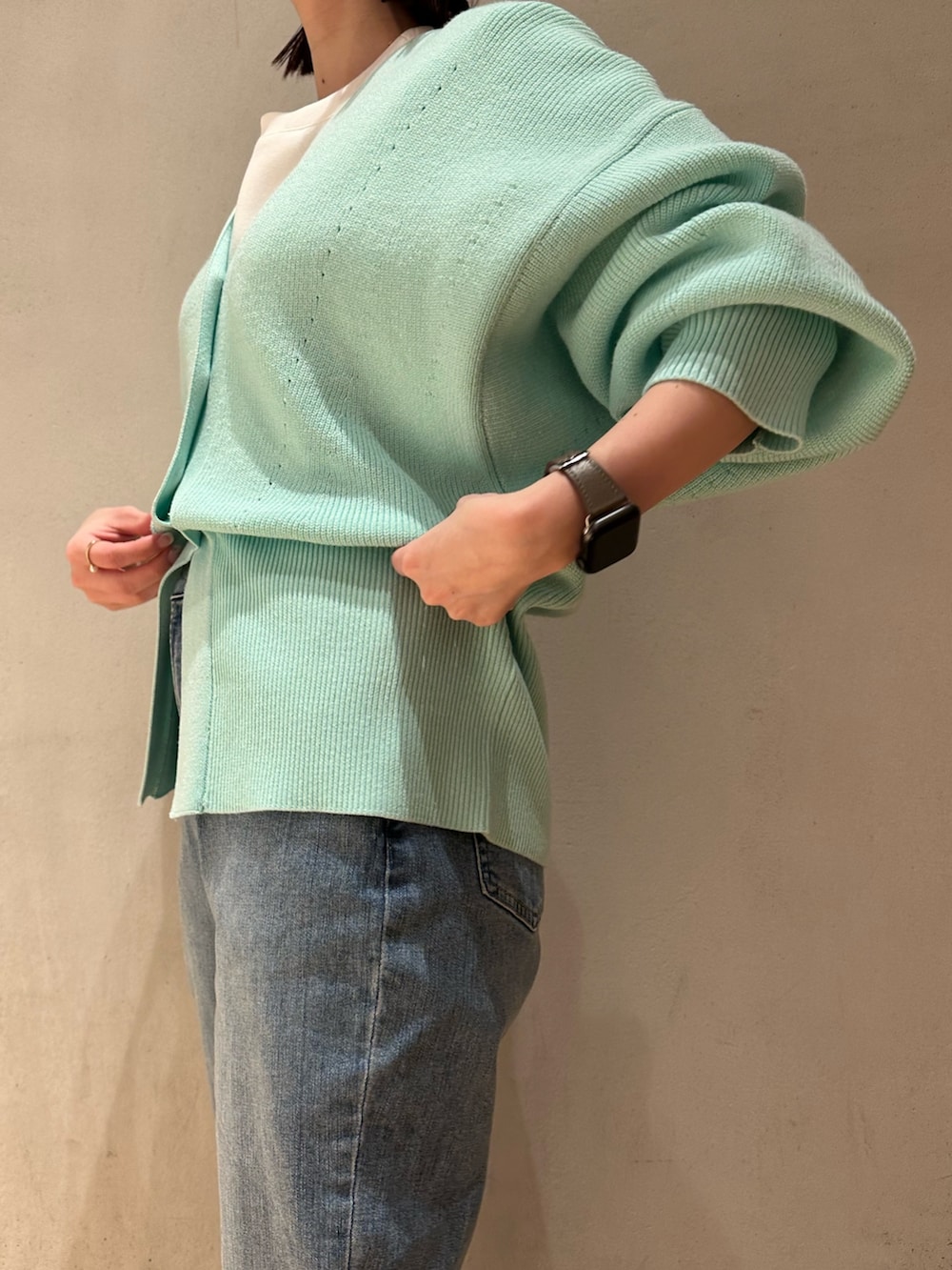 ブルー系のデニムパンツ、グリーン系のカーディガン/ボレロ、ホワイト系のTシャツ/カットソーを着用したレディースの冬コーディネートの7枚目の写真