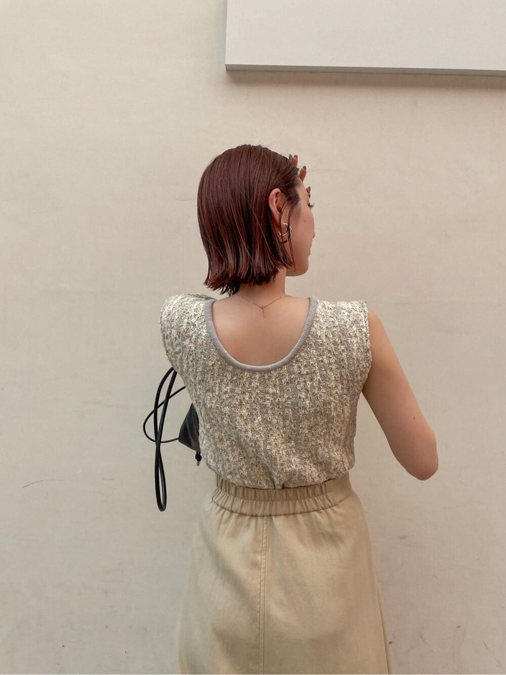 レッド系のサンダル、ベージュ系のスカート、グレー系のニット/セーターを着用したレディースの夏コーディネートの3枚目の写真