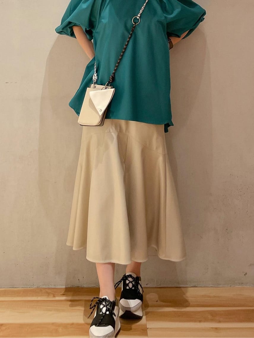 ベージュ系のスカート、ブルー系のスニーカー、グリーン系のシャツ/ブラウスを着用したレディースの秋コーディネートの2枚目の写真