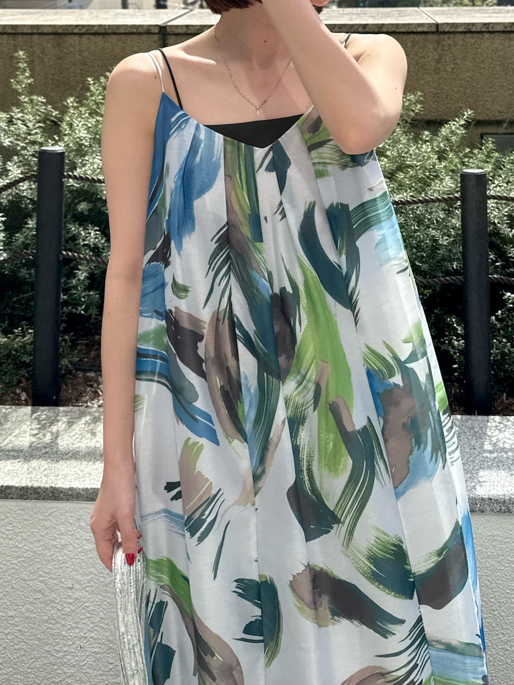 グリーン系のワンピース、シルバー系のトートバッグ、シルバー系のサンダルを着用したレディースの春コーディネートの7枚目の写真