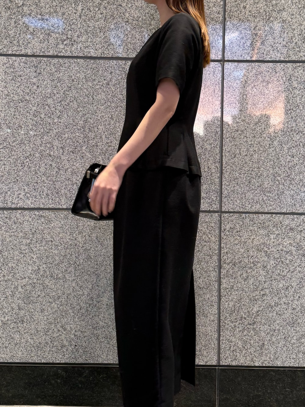 ブラック系のワンピース、ブラック系のハンドバッグを着用したレディースの冬コーディネートの4枚目の写真