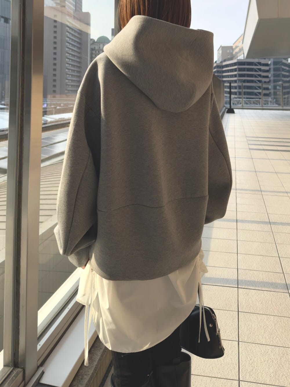 グレー系のパーカー、ブラック系のボストンバッグを着用したレディースの冬コーディネートの8枚目の写真