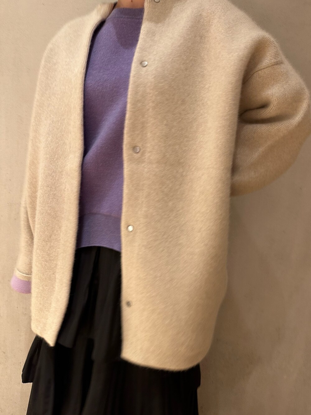 ブラック系のスカート、ホワイト系のノーカラージャケット、パープル系のニット/セーターを着用したレディースの夏コーディネートの6枚目の写真