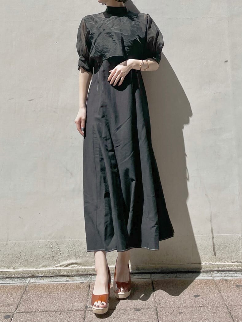 ブラウン系のパンプス、ブラック系のワンピース、ゴールド系のブレスレットを着用したレディースの春コーディネートの2枚目の写真