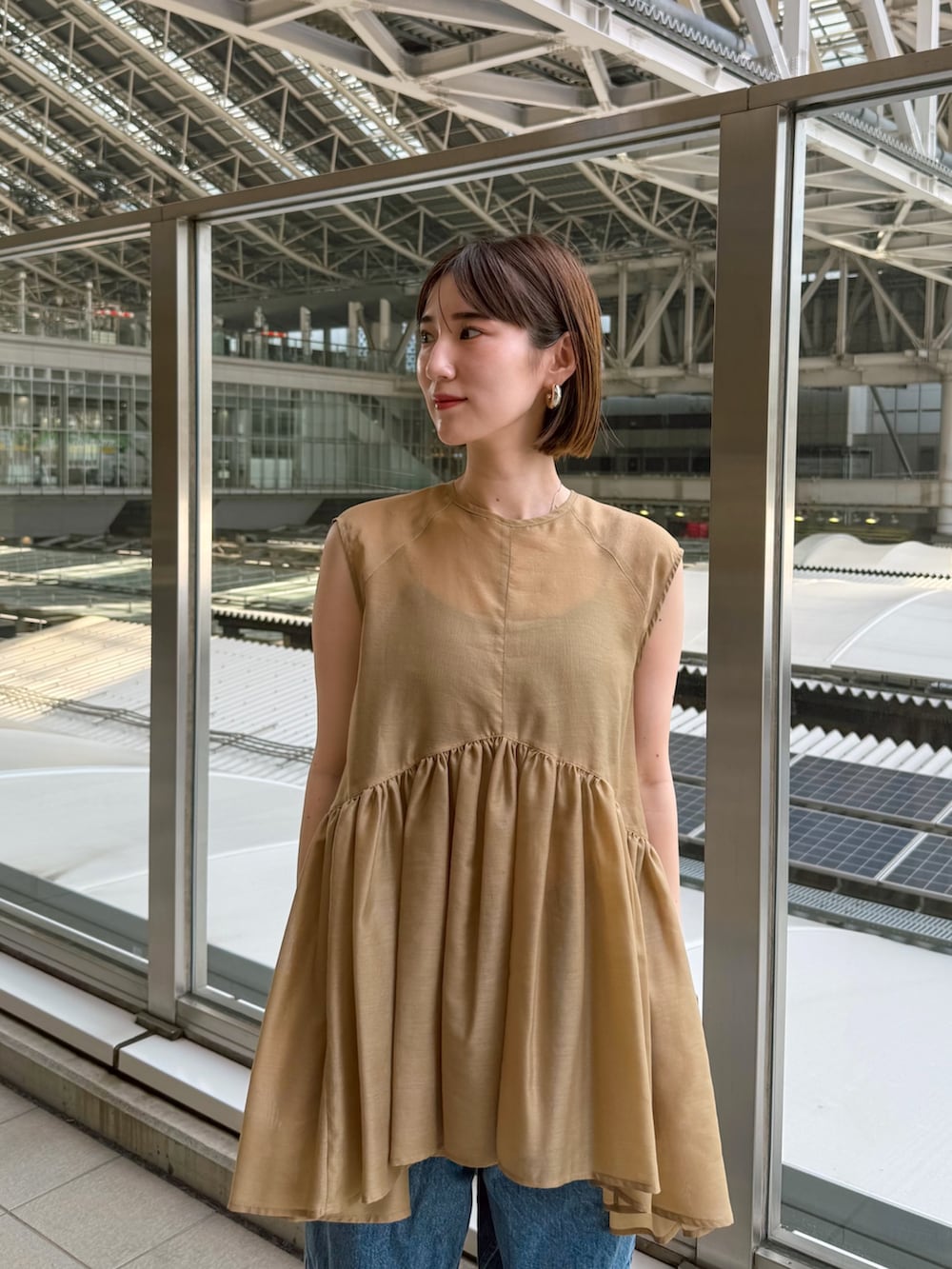 イエロー系のシャツ/ブラウス、ブルー系のデニムパンツを着用したレディースの夏コーディネートの5枚目の写真