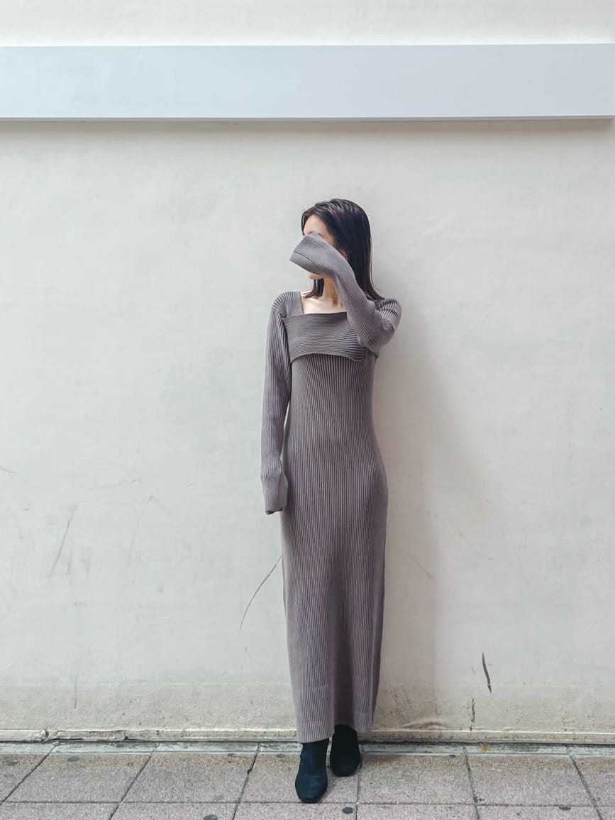 ブラック系のブーツ、ホワイト系のその他アウター、ベージュ系のワンピースを着用したレディースの秋コーディネートの2枚目の写真