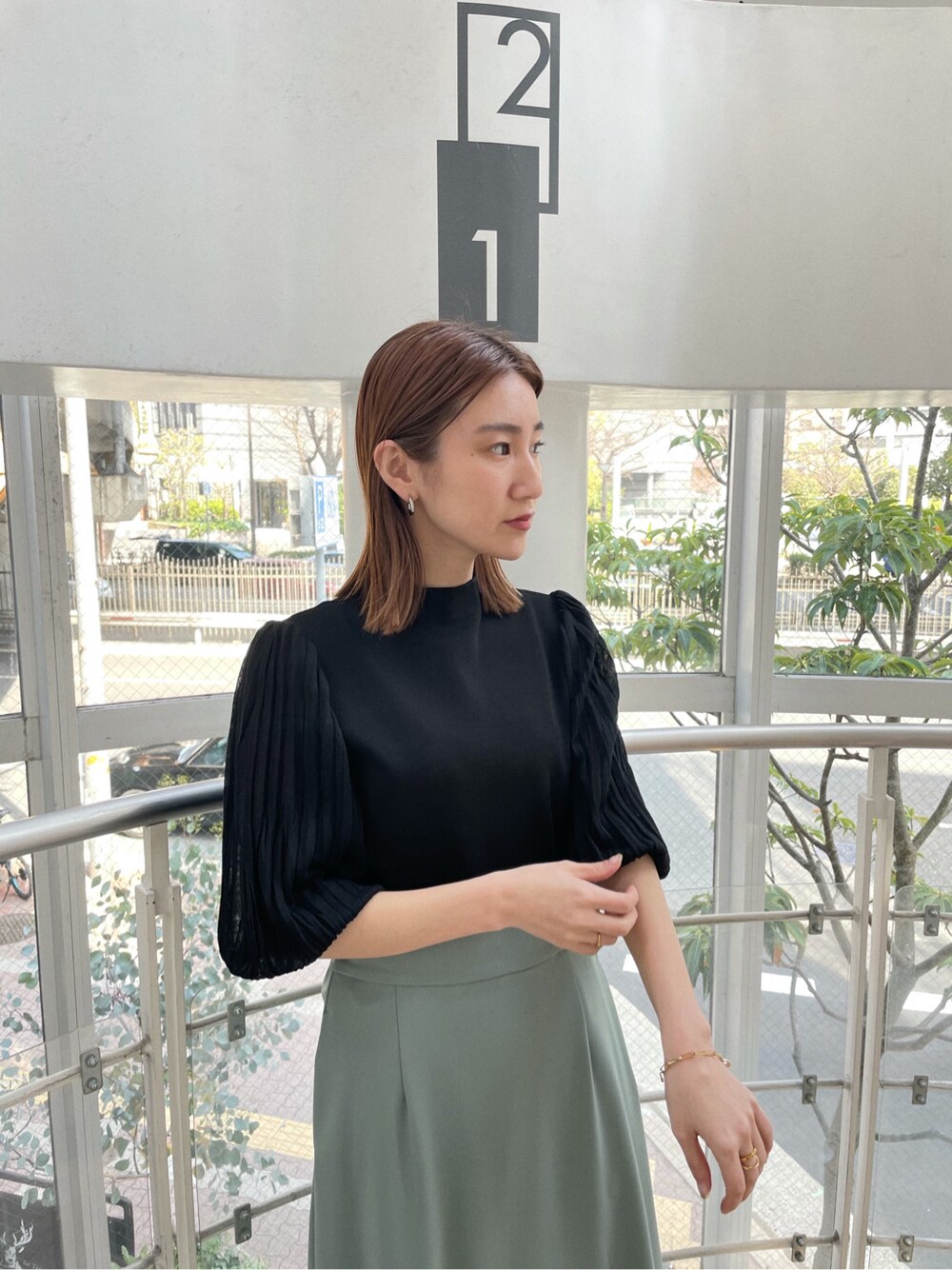 グリーン系のスカート、その他のパンプス、ベージュ系のその他アウターを着用したレディースの春コーディネートの7枚目の写真