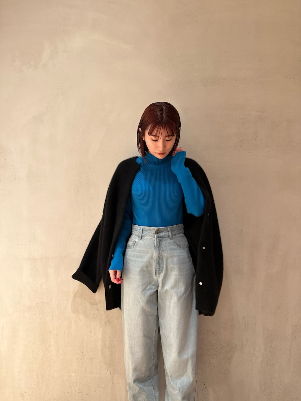 ブラック系のノーカラージャケット、ブルー系のニット/セーター、ブルー系のデニムパンツを着用したレディースの夏コーディネートの2枚目の写真