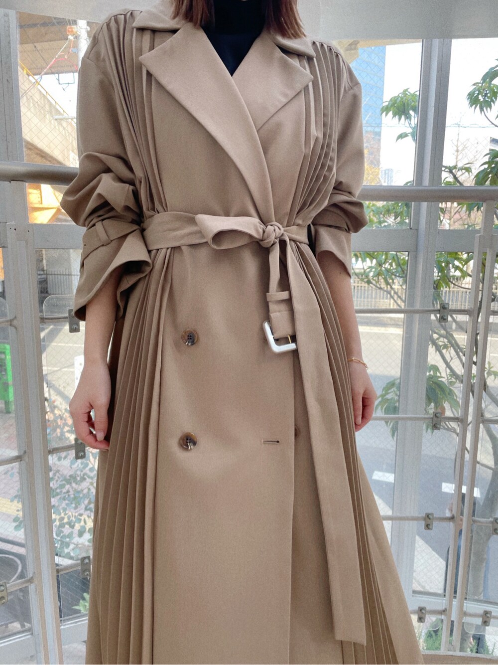 グリーン系のスカート、その他のパンプス、ベージュ系のその他アウターを着用したレディースの春コーディネートの2枚目の写真