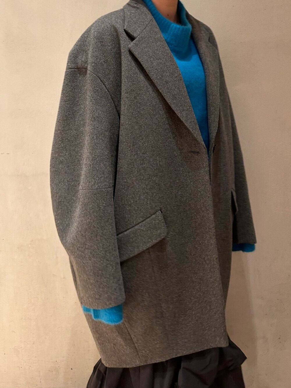 ブラック系のスカート、ブルー系のニット/セーター、ホワイト系のブーツを着用したレディースの冬コーディネートの10枚目の写真