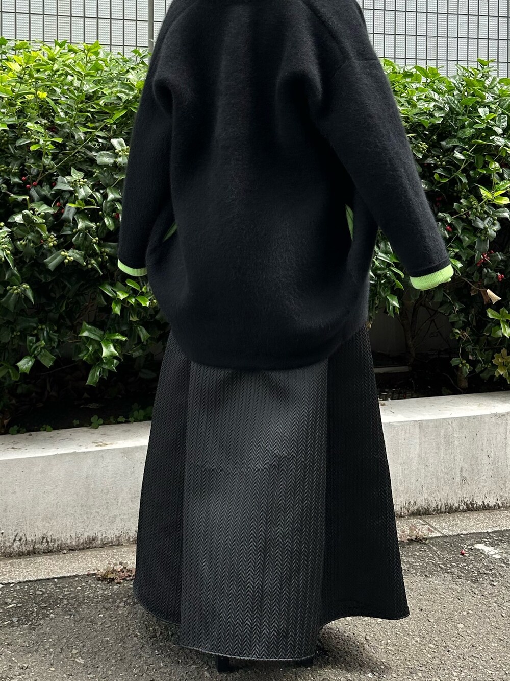 ブラック系のノーカラージャケット、ブラック系のスカート、ブラック系のパンプスを着用したレディースの夏コーディネートの9枚目の写真