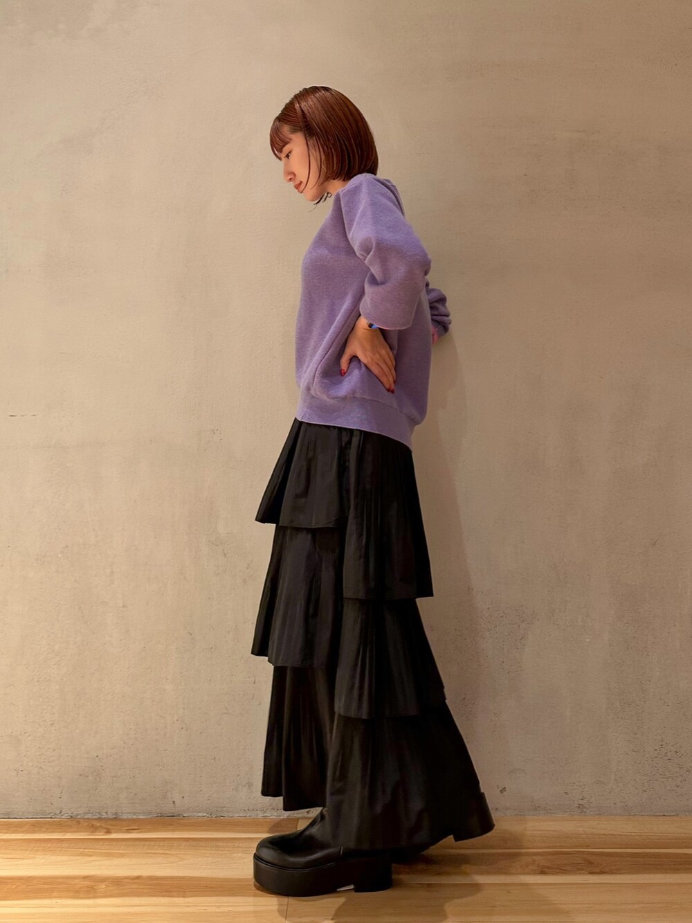 ブラック系のスカート、ホワイト系のノーカラージャケット、パープル系のニット/セーターを着用したレディースの夏コーディネートの2枚目の写真