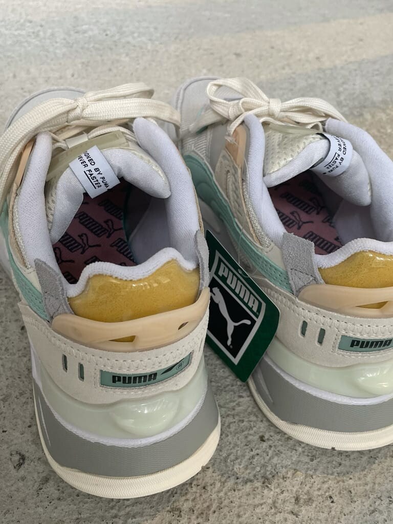 グレー系のスカート、ホワイト系のスニーカー、ブラック系のニット/セーターを着用したレディースの夏コーディネートの7枚目の写真