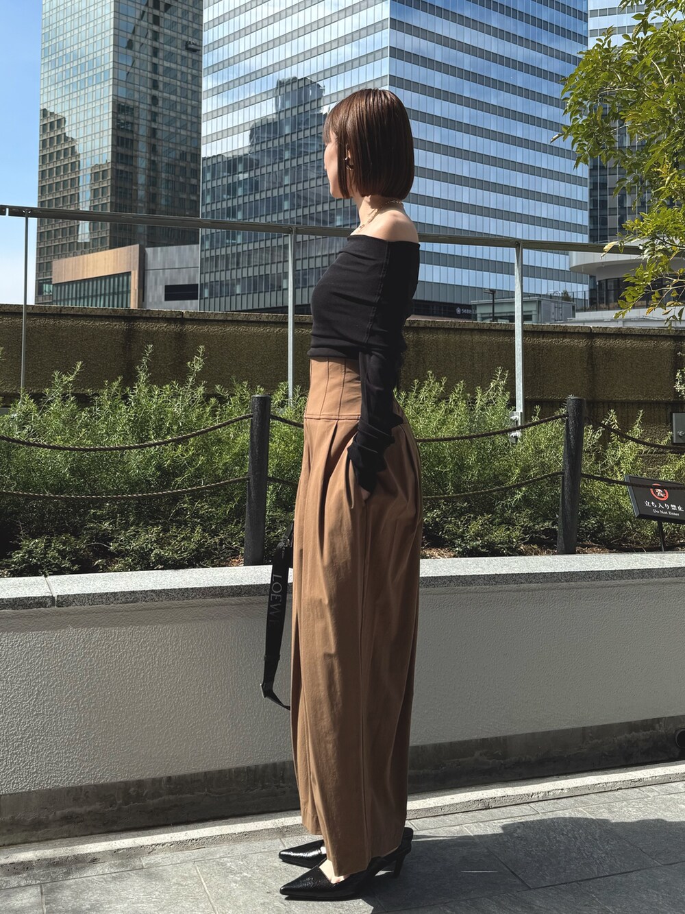 ブラック系のTシャツ/カットソー、ブラック系のサンダル、ブラウン系のその他パンツを着用したレディースの春コーディネートの5枚目の写真
