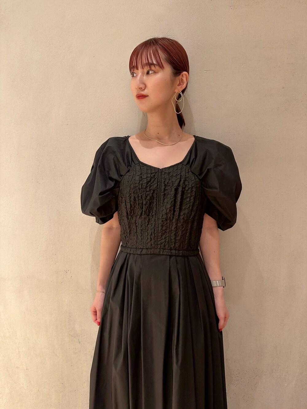 ブラック系のワンピース、ホワイト系のスニーカー、ゴールド系のピアス（両耳用）を着用したレディースの夏コーディネートの3枚目の写真