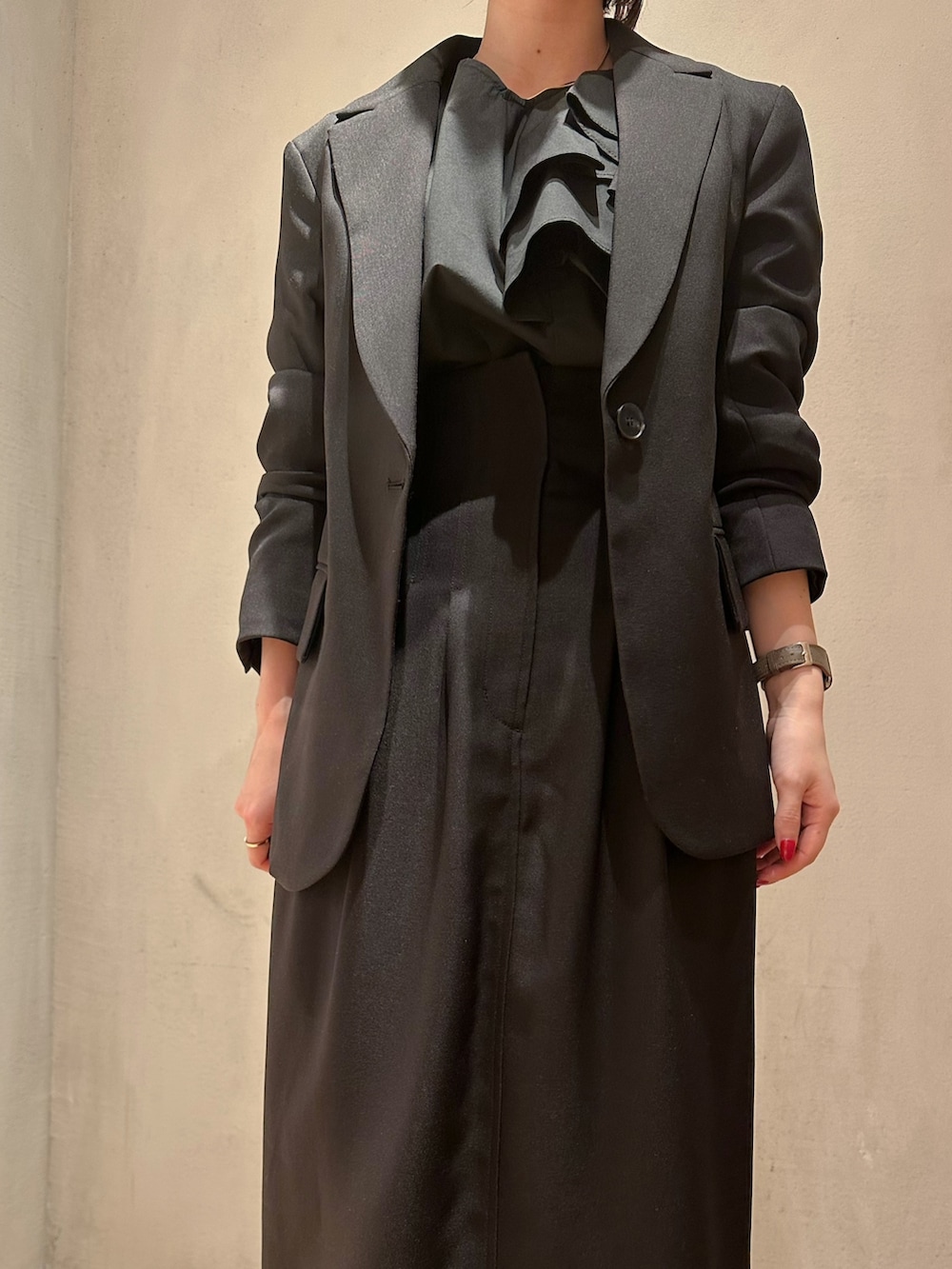 ブラック系のシャツ/ブラウス、ブラック系のテーラードジャケット、ブラック系のスカートを着用したレディースの冬コーディネートの3枚目の写真