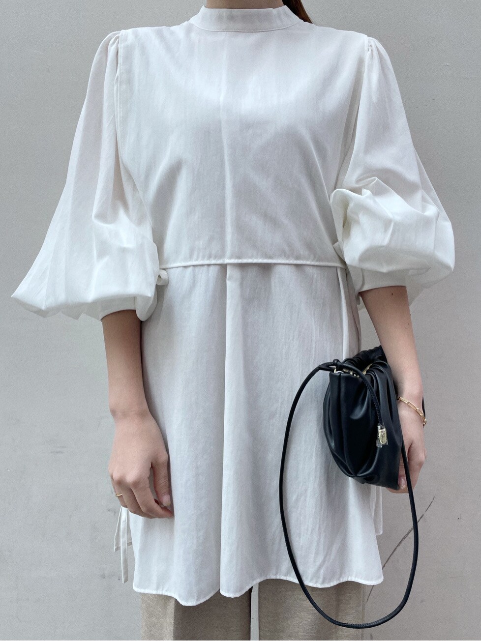 ホワイト系のシャツ/ブラウス、ブラック系のサンダル、ブラック系のハンドバッグを着用したレディースの春コーディネートの2枚目の写真