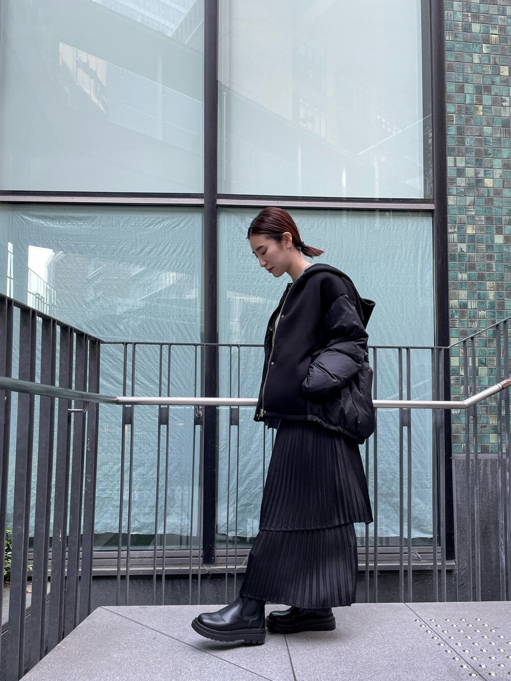 グレー系のワンピース、ブラック系のダウンジャケット/コート、ブラック系の財布を着用したレディースの冬コーディネートの7枚目の写真