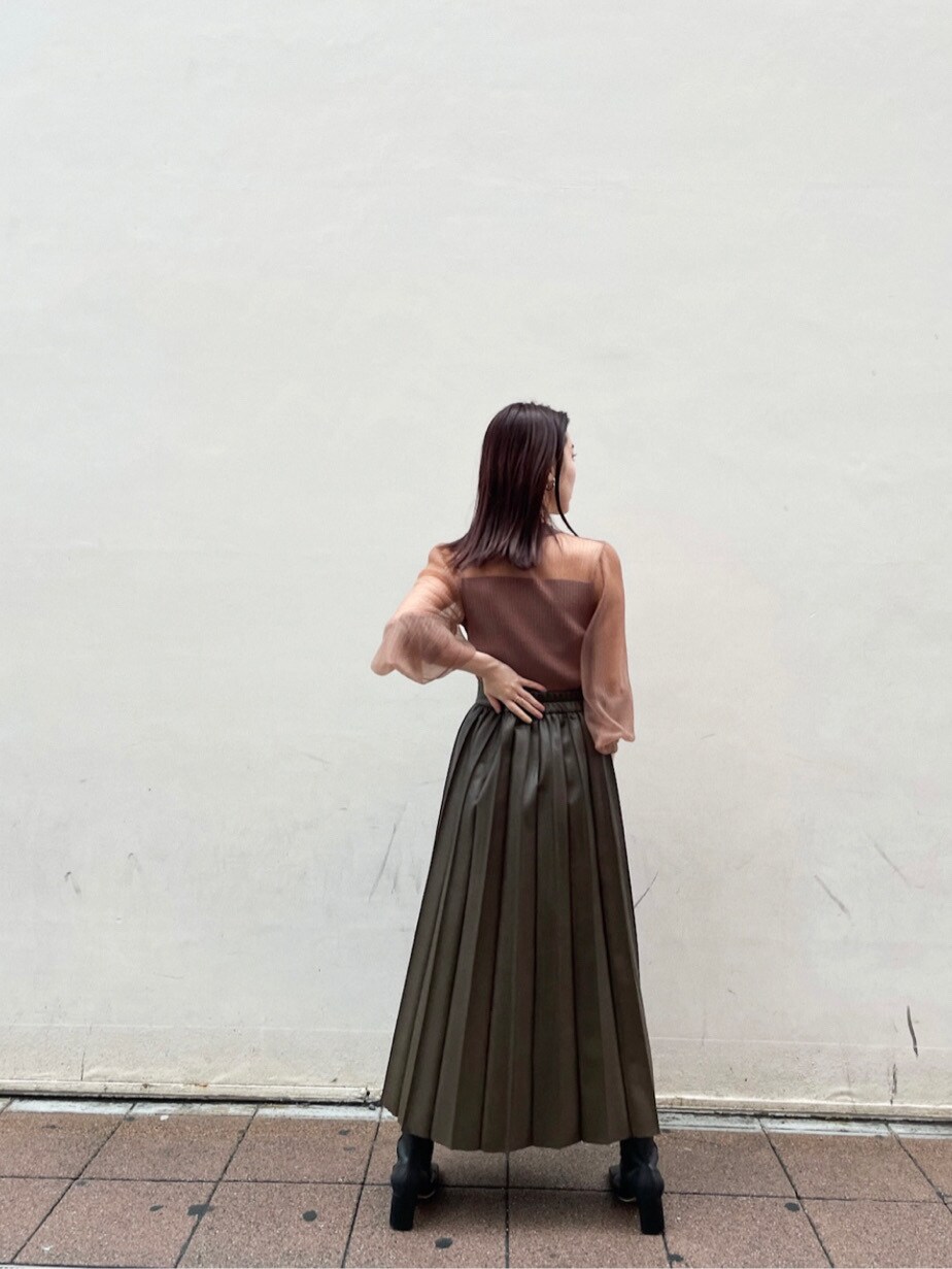 ブラウン系のスカート、ホワイト系のムートンコート、ベージュ系のニット/セーターを着用したレディースの冬コーディネートの4枚目の写真