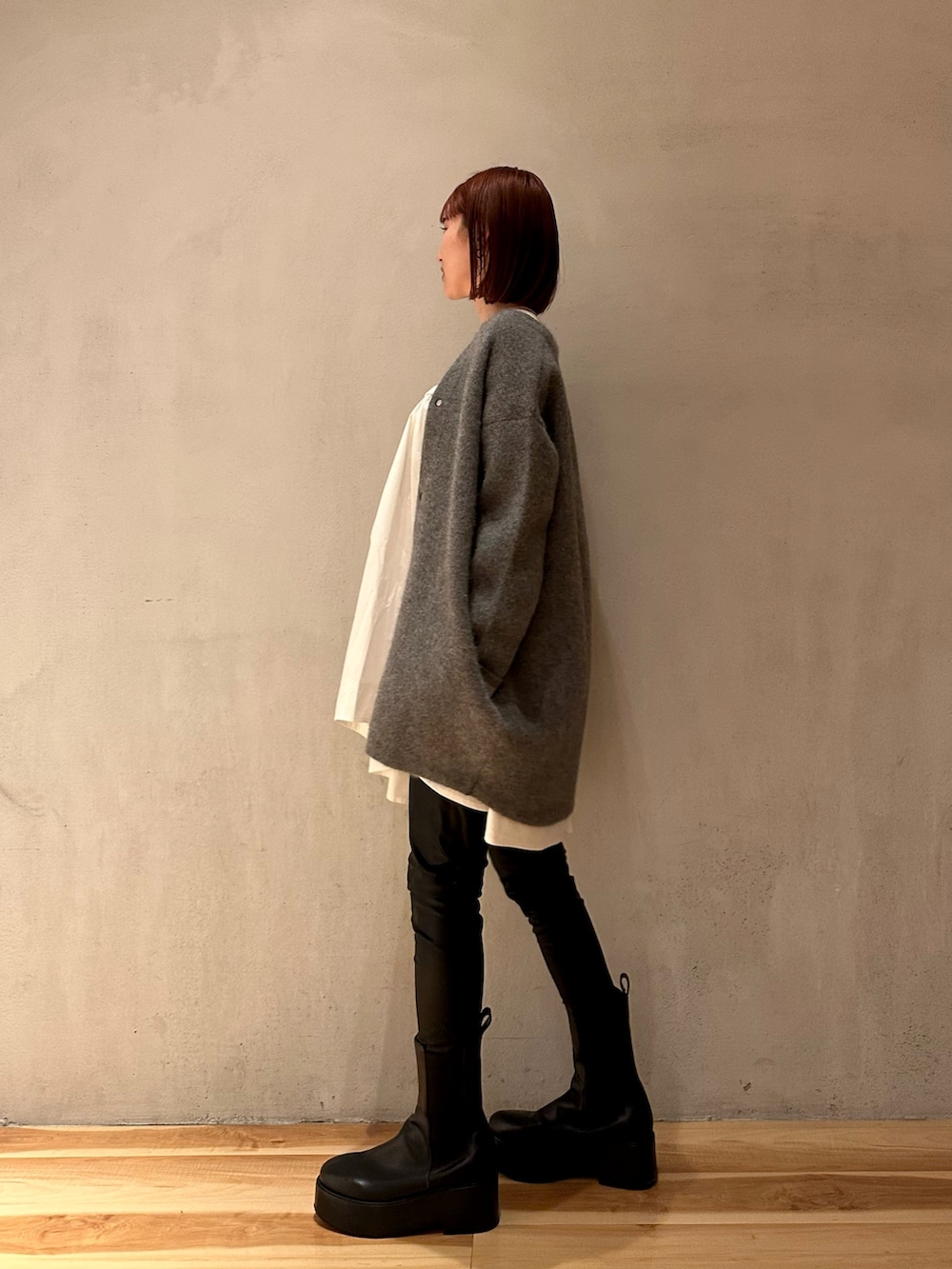 ブラック系のブーツ、ホワイト系のシャツ/ブラウス、グレー系のカーディガン/ボレロを着用したレディースの夏コーディネートの2枚目の写真