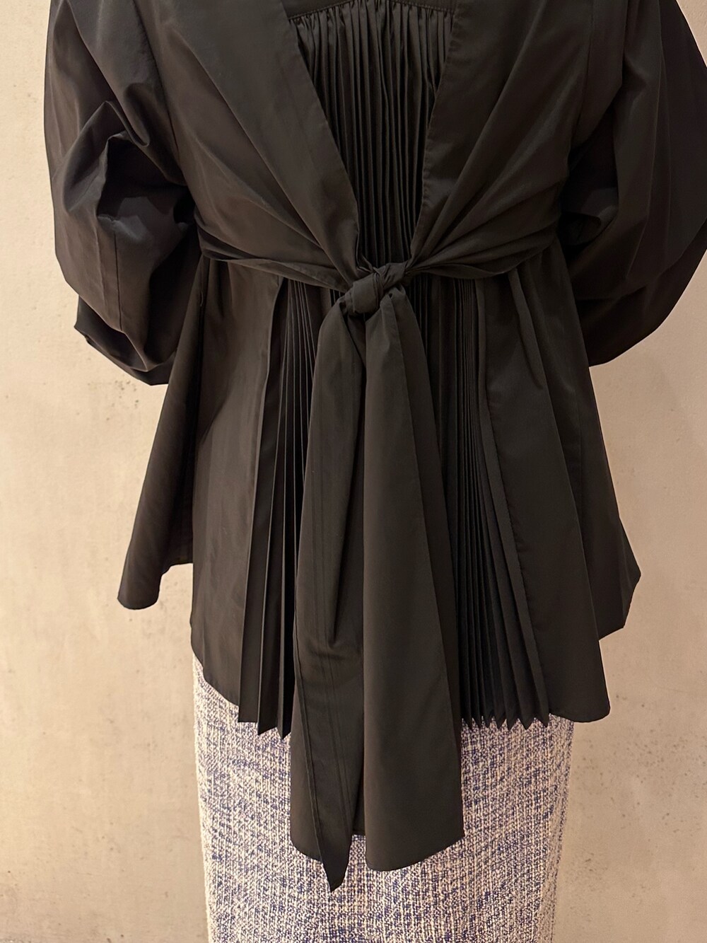 ブラック系のシャツ/ブラウス、ホワイト系のスニーカー、ブルー系のスカートを着用したレディースの春コーディネートの6枚目の写真