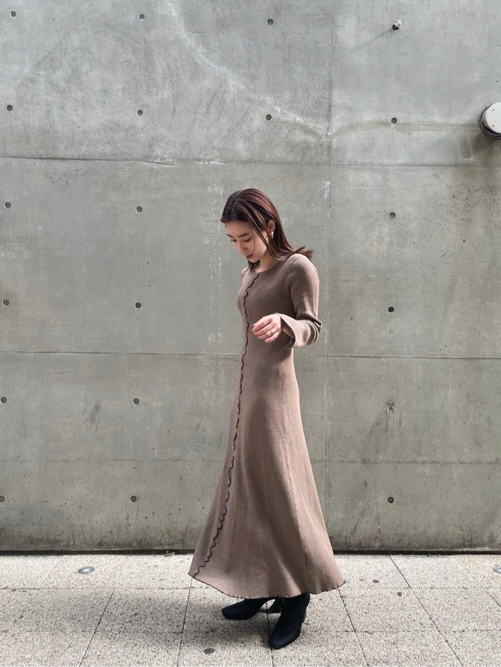 ベージュ系のワンピース、レッド系のパーカーを着用したレディースの冬コーディネートの3枚目の写真