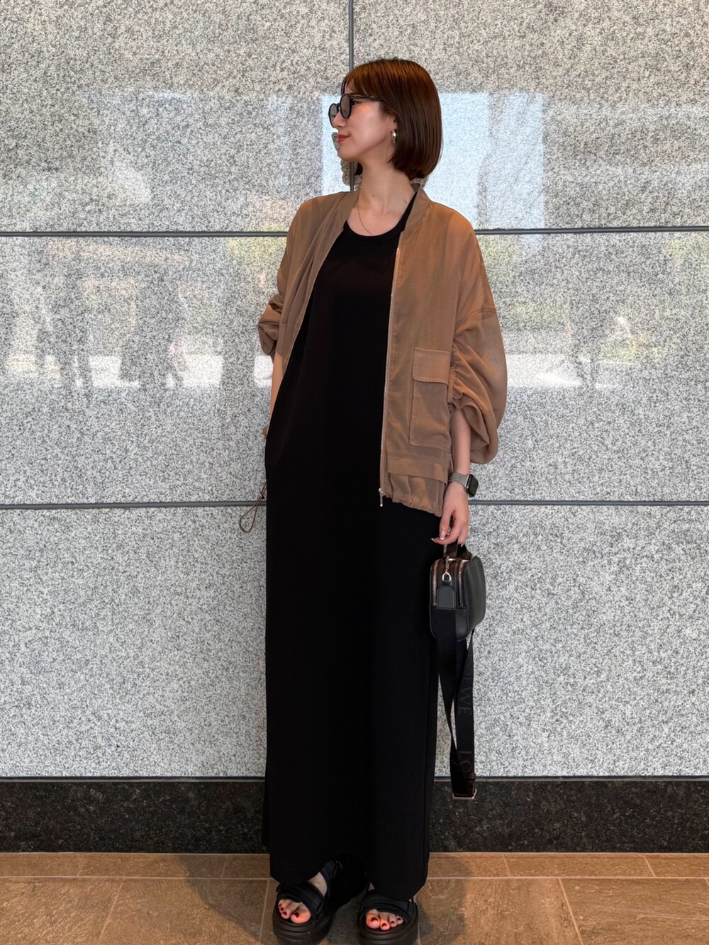 ベージュ系のブルゾン、ブラック系のワンピース、ブラック系のサングラスを着用したレディースの夏コーディネートの3枚目の写真