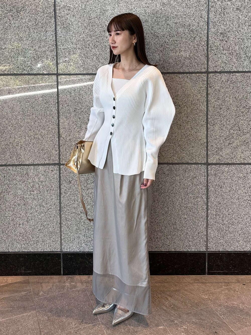 ホワイト系のカーディガン/ボレロ、ベージュ系のスカート、シルバー系のサンダルを着用したレディースの秋コーディネートの3枚目の写真