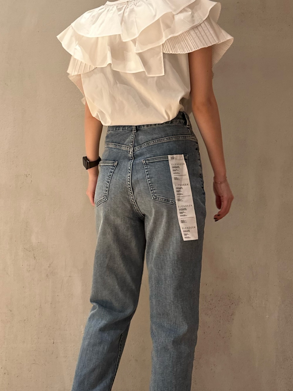 ホワイト系のシャツ/ブラウス、ブラック系のスニーカー、ブルー系のデニムパンツを着用したレディースの春コーディネートの6枚目の写真