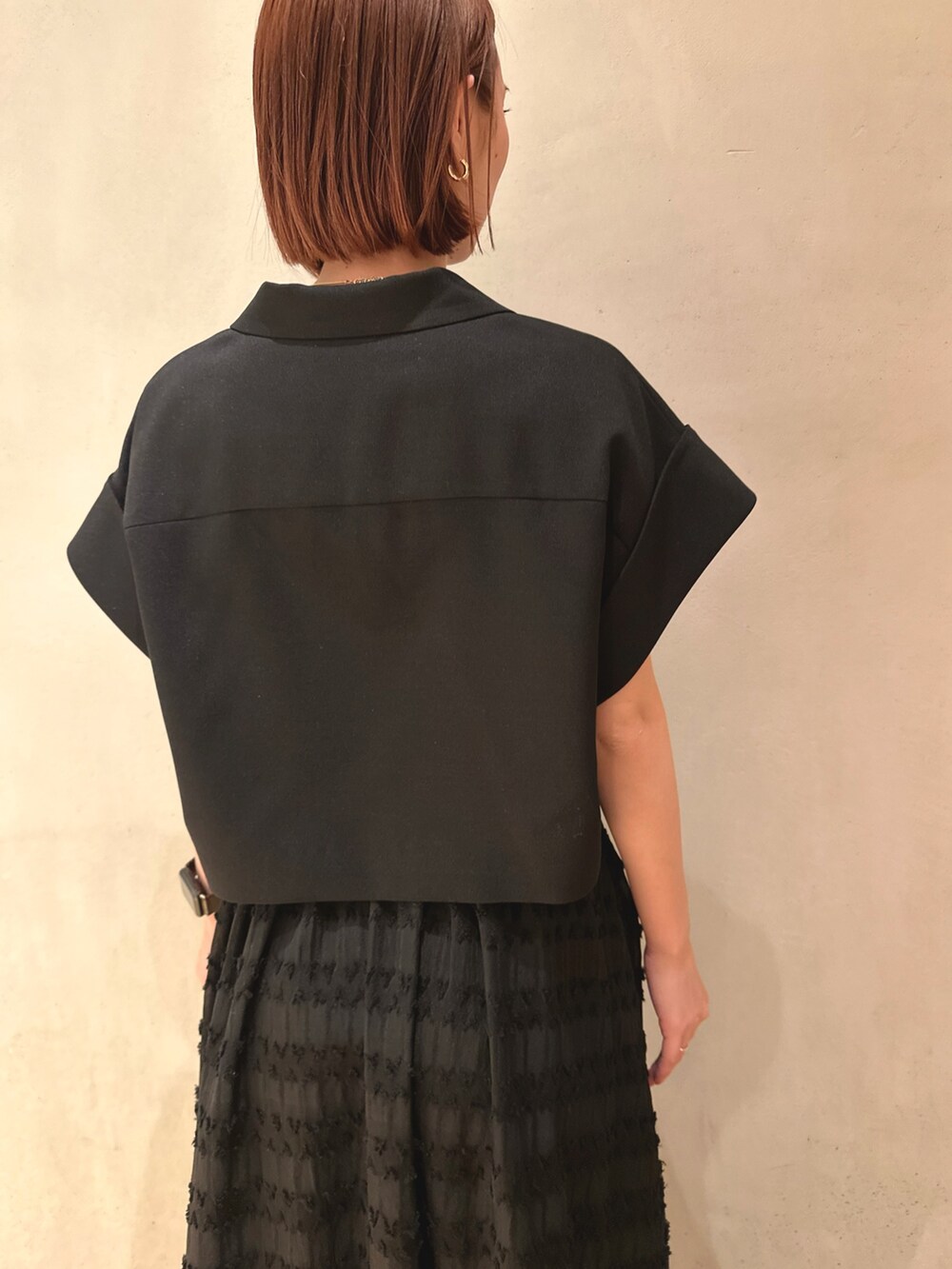 ブラック系のテーラードジャケット、ホワイト系のスニーカー、ブラック系のスカートを着用したレディースの春コーディネートの6枚目の写真