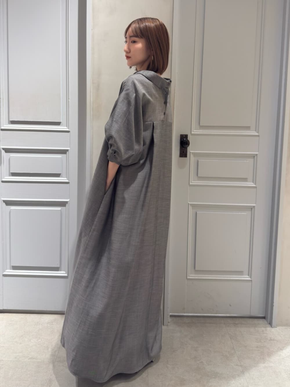 ブラック系のパンプス、グレー系のワンピースを着用したレディースの春コーディネートの2枚目の写真